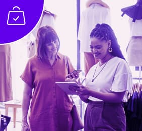 Two female co-workers collaborating on a project in their clothing retail store